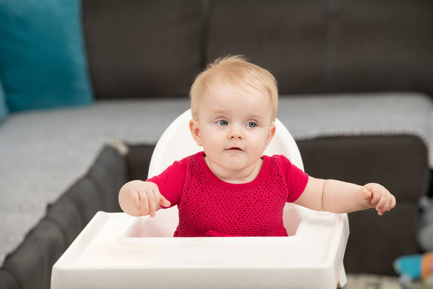 Portrait of a Joyful Baby Sitting on a High Chair - Фото, зображення