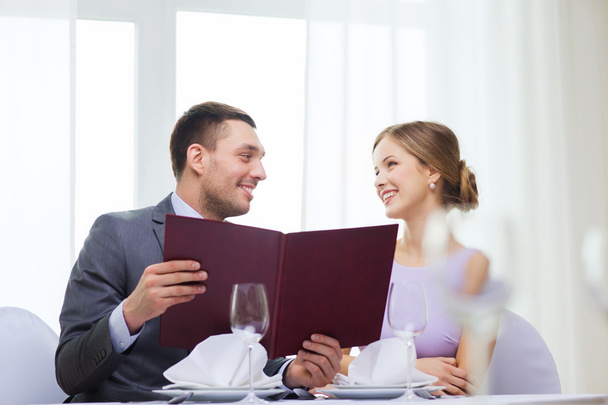 Smiling couple with menu at restaurant - 写真・画像