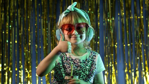 Trendy stylisches Kind mit Ananasfruchtsaft in futuristischem Club mit Neonlicht - Foto, Bild