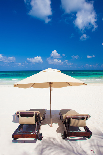 iki sandalye ve beyaz kum plaj şemsiyesi. tatil - Fotoğraf, Görsel
