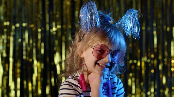Стильна модна дитина в сонцезахисних окулярах на вечірці кіберпанк клуб дивиться на камеру і посміхається
 - Фото, зображення