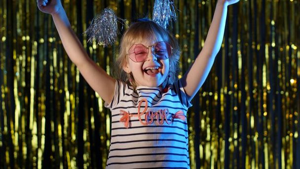 Nettes kleines Mädchen genießt den Erfolg, feiert den Sieg, freut sich über den Sieg, fühlt sich im Nachtclub motiviert - Foto, Bild