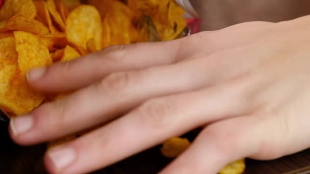 mão leva batatas fritas douradas da embalagem - Filmagem, Vídeo