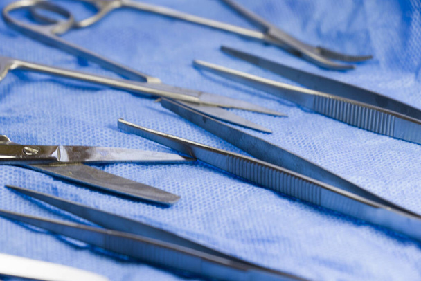 A set of stainless steel dissecting kit on blue sterile table - 写真・画像