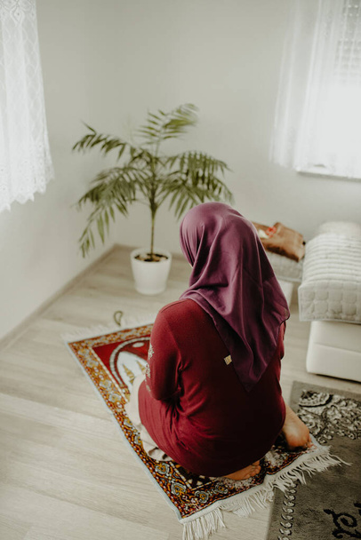 A vertical closeup shot of a Muslim female praying on a carpet - Fotografie, Obrázek