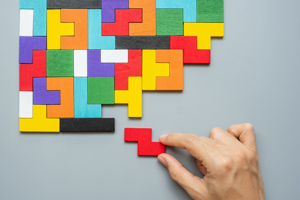 hand verbinden geometrische vorm blok met kleurrijke houten puzzelstukjes. logisch denken, bedrijfslogica, Conundrum, beslissing, oplossingen, rationeel, missie, succes, doelen en strategieconcepten - Foto, afbeelding