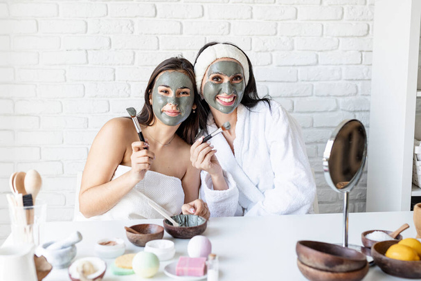 két gyönyörű nő alkalmazza arc maszk szórakozás - Fotó, kép