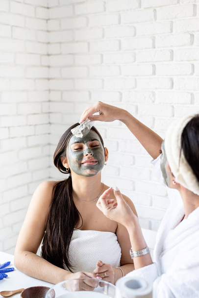 dos hermosas mujeres aplicando mascarilla facial haciendo procedimientos de spa - Foto, Imagen