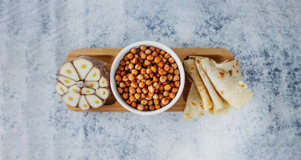 Leblebi Turkish delicacy of fried chickpeas, garlic and tortillas on compartmental dish, long format banner, selective focus - Foto, Imagen