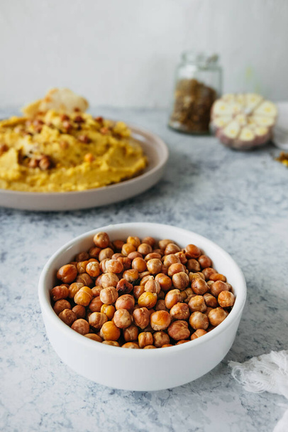 leblebi türkische Delikatesse aus gebratenen Kichererbsen in Porzellanteller in der Küche, vertikaler Lebensmittelgehalt, selektiver Fokus - Foto, Bild