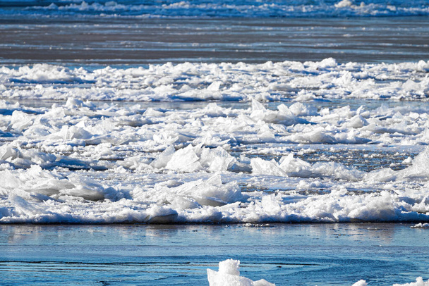 La fonte de la glace flottant sur la rivière par une journée ensoleillée de printemps. Texture de glace fissurée. - Photo, image