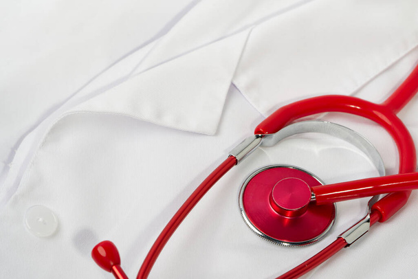 Red stethoscope on white background, close up - Foto, afbeelding