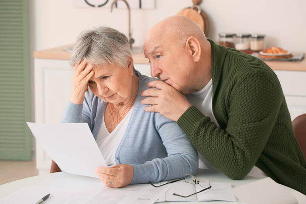 Stressed senior couple in debt at home - Foto, Imagen