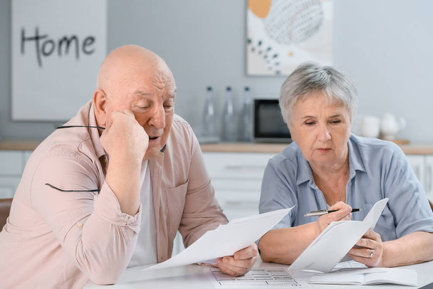 Stressed senior couple in debt at home - Foto, imagen