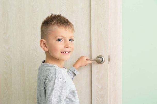 słodkie mały chłopiec otwarcie drzwi w pokój - Zdjęcie, obraz