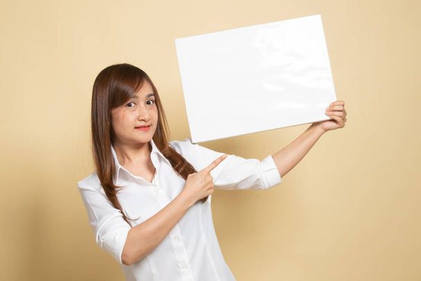 Young Asian woman point to  blank sign on beige background - Foto, Bild