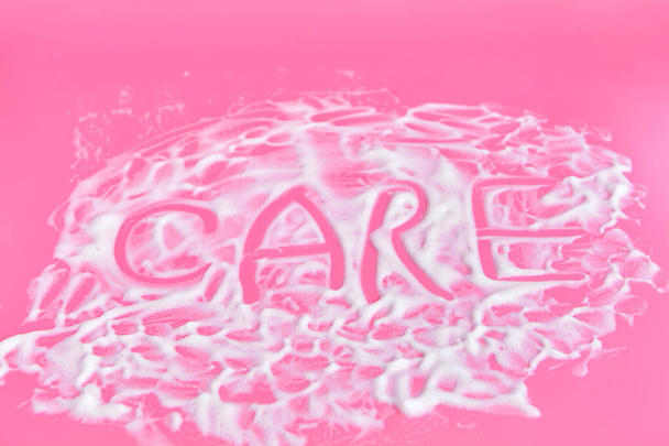 Washing concept. Soap foam on delicate pink background with copy space - Photo, Image