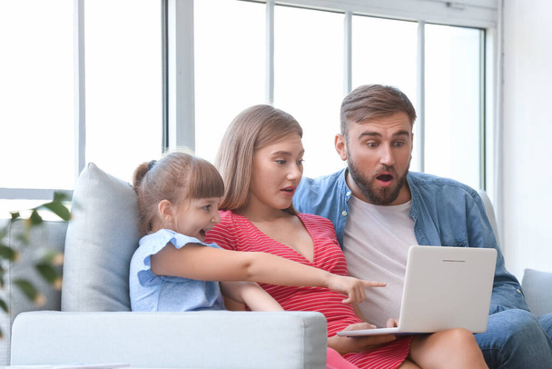 Überraschte Familie mit Laptop zu Hause - Foto, Bild