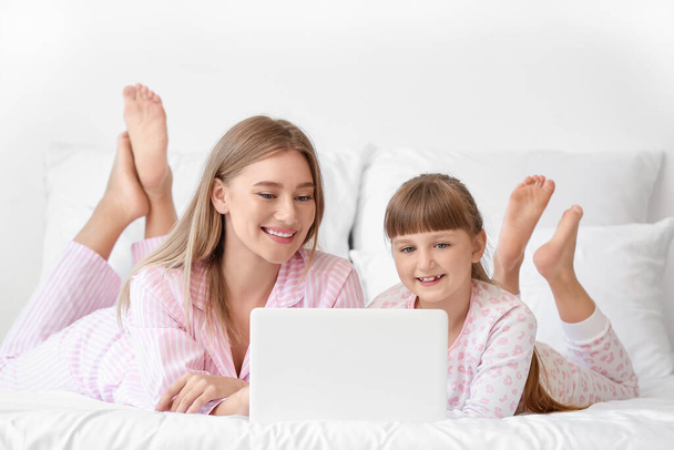 Mother and daughter with laptop in bedroom - Фото, зображення