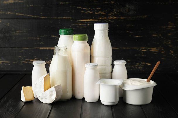 Diferentes productos lácteos sobre fondo de madera oscura - Foto, imagen
