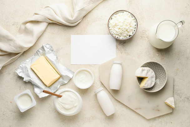 Diferentes productos lácteos con tarjeta en blanco sobre fondo claro - Foto, Imagen
