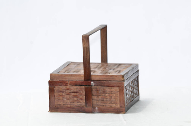 Een traditionele handgemaakte doos gemaakt van bamboe met deksel en handvat - Foto, afbeelding