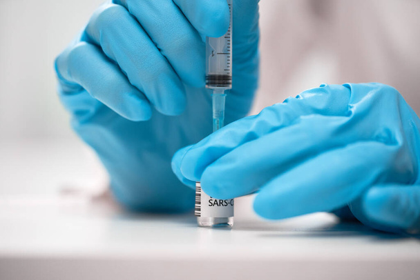 Doctor dials the vaccine into a syringe - Valokuva, kuva
