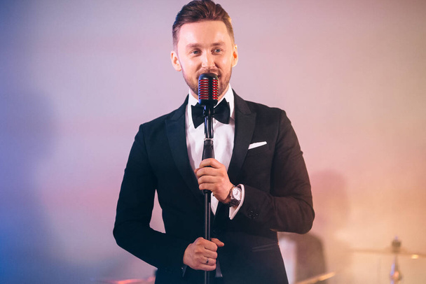 man in a suit singing on stage - Photo, Image