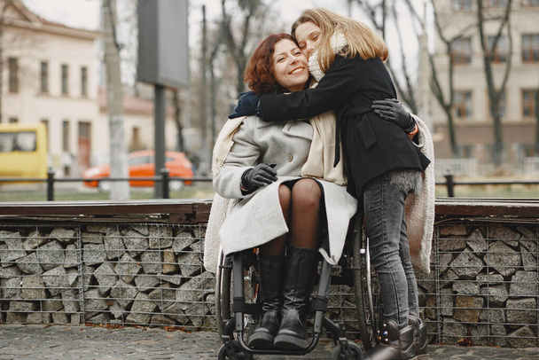 Mother in a wheelchair with hre daughter - Photo, Image