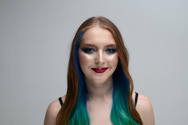 Photo portrait of a model with excellent makeup. Caucasian girl with long dyed hair - Fotó, kép
