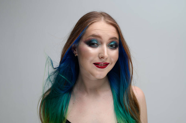 Caucasian girl with long dyed hair. Photo portrait of a model with excellent makeup. - Fotó, kép