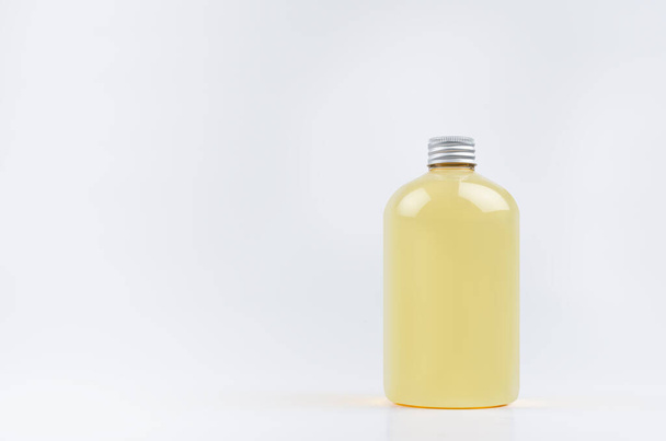 Transparent plastic low thick bottle with orange drink, cooking oil or cosmetic produce with silver cap mockup on white background, template, copy space. - Fotó, kép