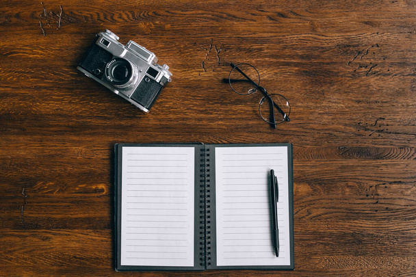 Notepad, camera and glasses. Top view, flat lay - Photo, image
