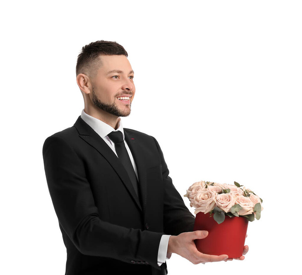 Handsome man with bouquet of beautiful flowers on white background - Photo, Image