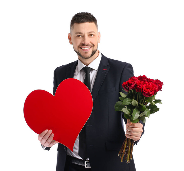 Knappe man met boeket van mooie bloemen en rood hart op witte achtergrond - Foto, afbeelding