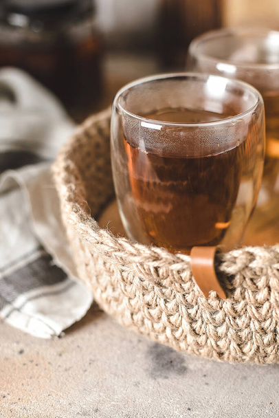 Glass of hot tea in jute basket in home interior. Breakfast food concept. - Valokuva, kuva