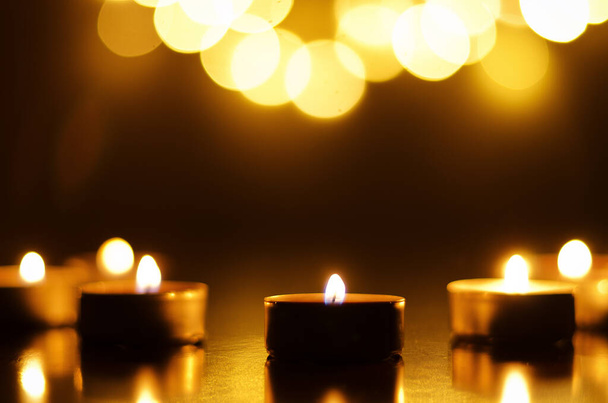Палаючі свічки зі святковим боке на чорному тлі. Концепція свята. Поняття молитви і надії
. - Фото, зображення