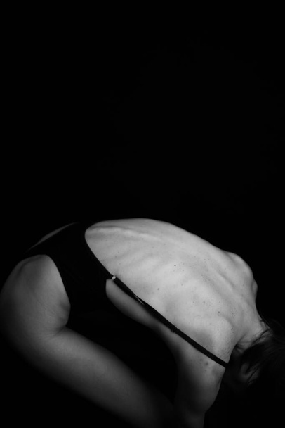 женский спин на темном фоне, части тела женщины  - Фото, изображение
