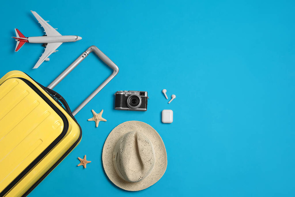 Flat lay composition with suitcase and travel accessories on light blue background, space for text. Summer vacation - Fotografie, Obrázek
