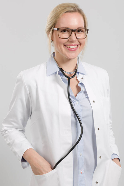 Portrait d'une femme amicale médecin de famille dans l'ensemble du médecin avec stéthoscope - Photo, image
