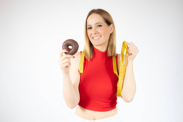 Mujer Medición de peso corporal en báscula de pesaje con rosquillas - Foto, Imagen