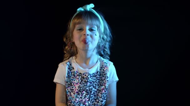 Portret van trendy stijlvolle meisje tonen tong, rommelen rond in neon licht in disco party studio - Video