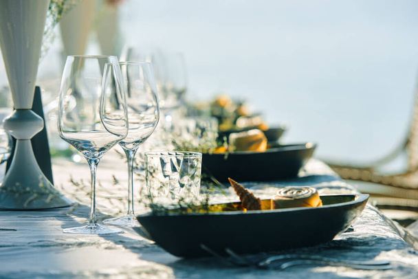 Festliche Tischdekoration Weingläser und Tischdekoration am Strand.. Fokus auf Teller mit Weinglas - Foto, Bild