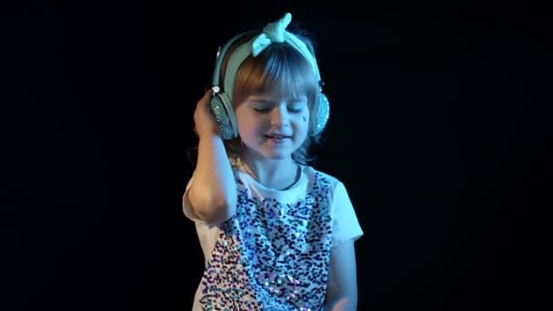 Futuristische hipster tiener meisje luisteren muziek in hoofdtelefoon, dansen in neon lichten in discotheek - Video