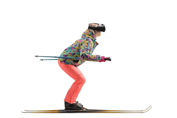 Full length profile shot of a female skiing isolated on a white background - Photo, Image