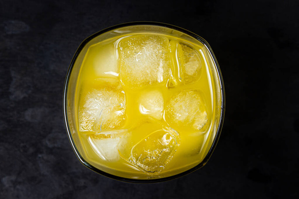 黒の背景にガラスの氷とジュース。天然マンゴージュース。飲み物 - 写真・画像