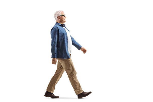 Full length profile shot of a casual mature man walking isolated on white background - Photo, image