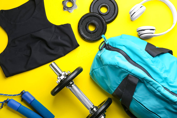 Flat lay composition with gym bag and sportswear on yellow background - Foto, Imagen