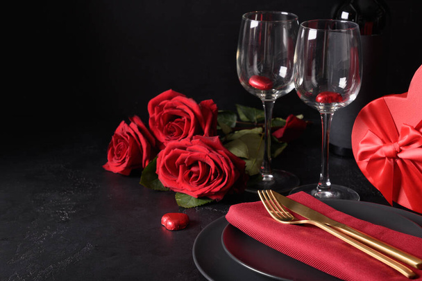 Red hearts chocolate sweets, wineglasses and red roses for Valentines day. - Photo, Image