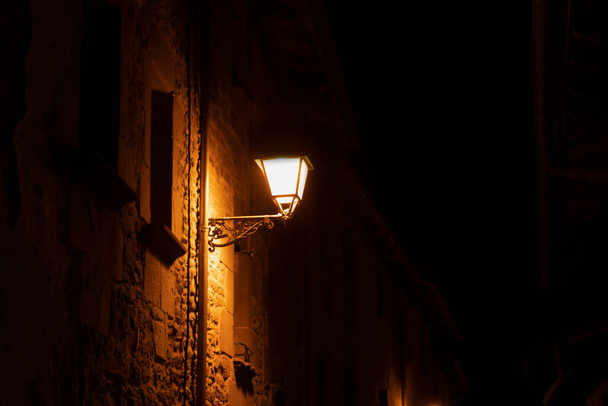 Barcelona yakınlarındaki Rupit 'teki eski İspanyol köyünde sarı lambalı eski caddenin gece manzarası. - Fotoğraf, Görsel